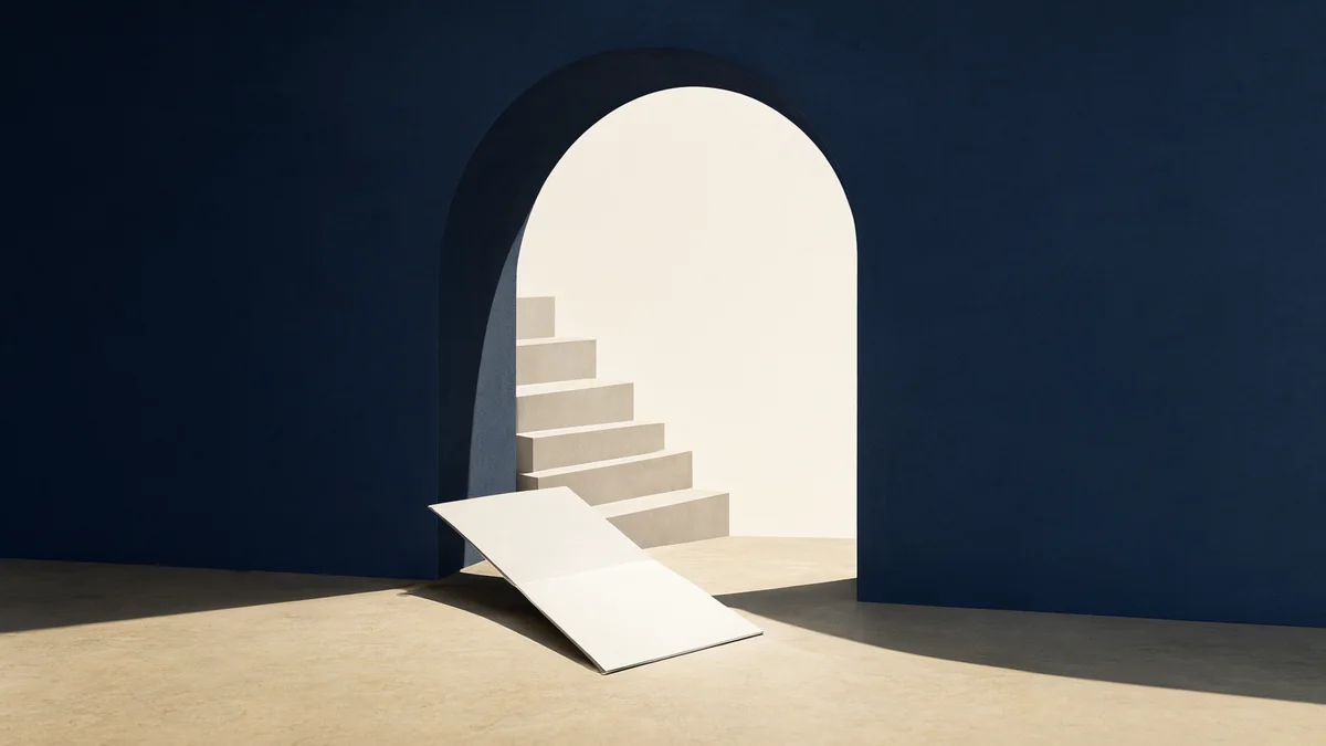 An open navy architectural form beside folded paper steps and a blank research folio.