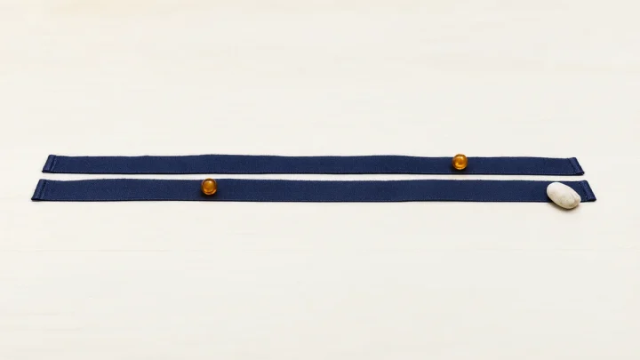 Two parallel ribbons with amber beads and a pale stone.