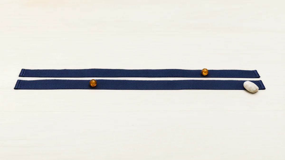 Two parallel ribbons with amber beads and a pale stone.